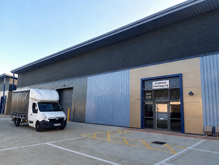 Photo of our new building with our van parked in front. The signs are artificially added but will be there in real life by now.