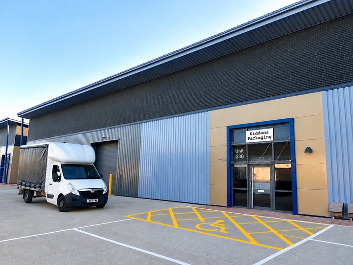 Photo of our new building with our van parked in front. The signs are artificially added but will be there in real life by now.